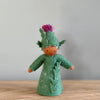 A felt Burdock Flower Fairy wearing a green dress and a pink flower in the hat with medium skin tone | © Conscious Craft